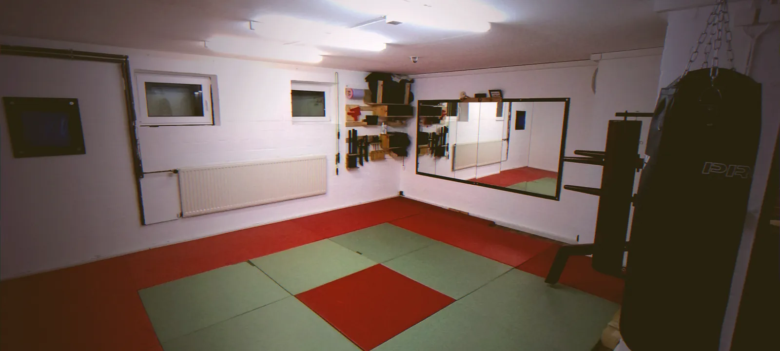Wing-Chun-Trainingsraum in Böhnhusen mit Matten, Holzpuppe und Sandsack